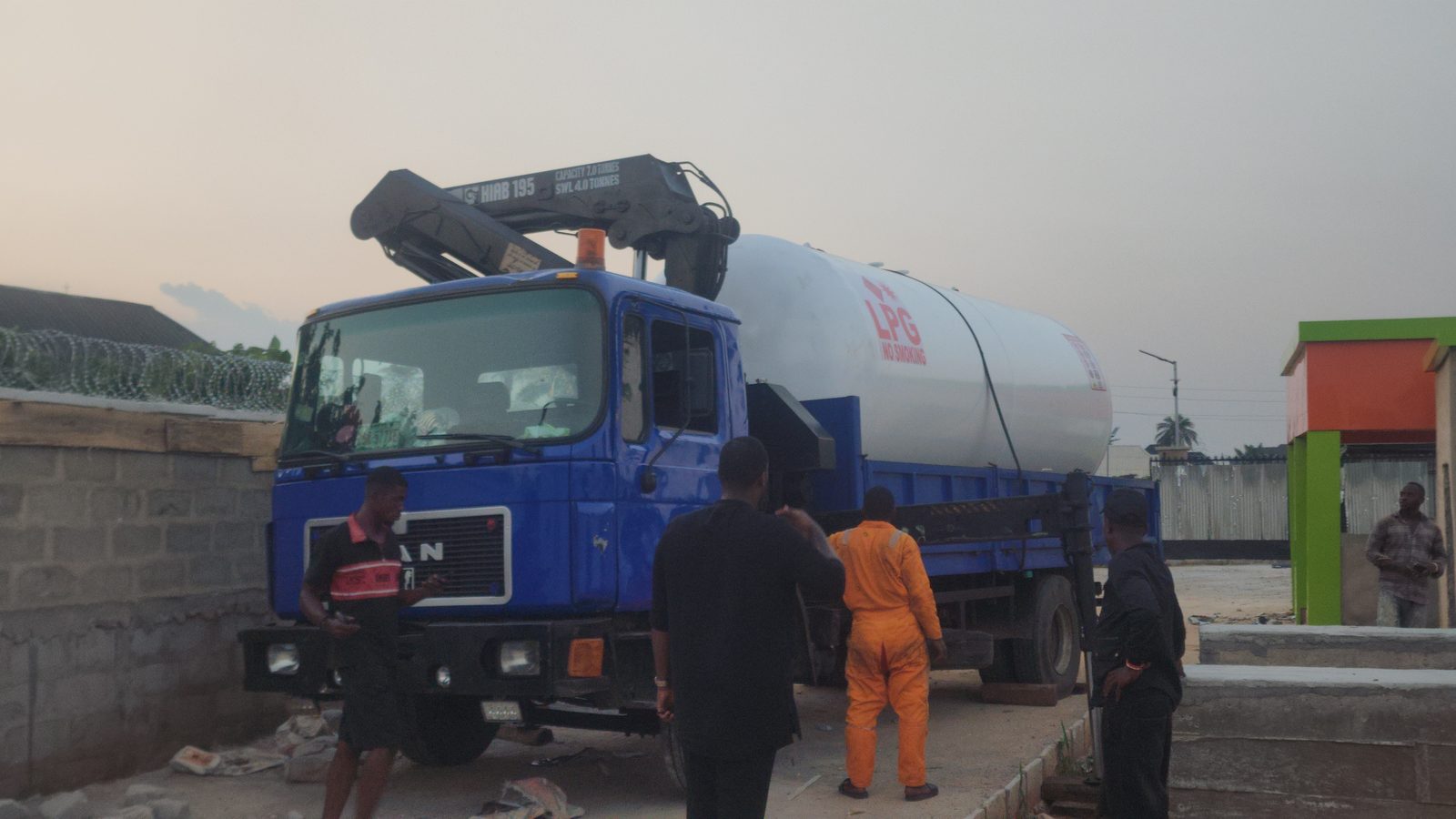 LPG tank being offloaded from delivery truck by crane